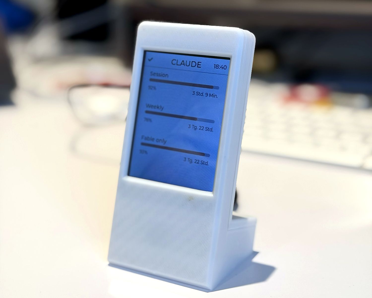 AI Monitor Display im Hochformat-Gehäuse auf dem Schreibtisch, mit Claude-Limits als Balken